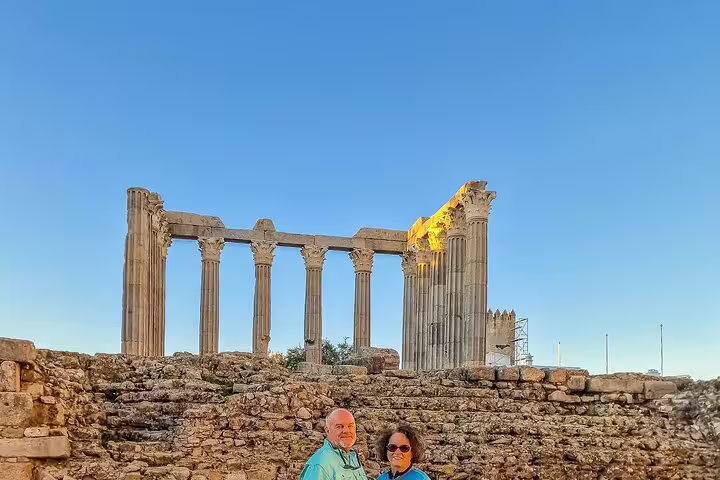 Ancient Roman Temple in Évora with tourists, part of the Lisbon to Madrid private transfer tour via Évora and Toledo.