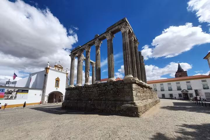 Ancient Roman Temple of Évora under a vibrant blue sky, showcasing historic architecture on the Evora & Monsaraz private tour.