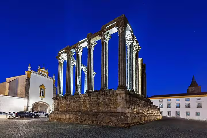 Illuminated Roman Temple of Évora at night, showcasing ancient architecture on a private guided day tour to Évora and Monsaraz.