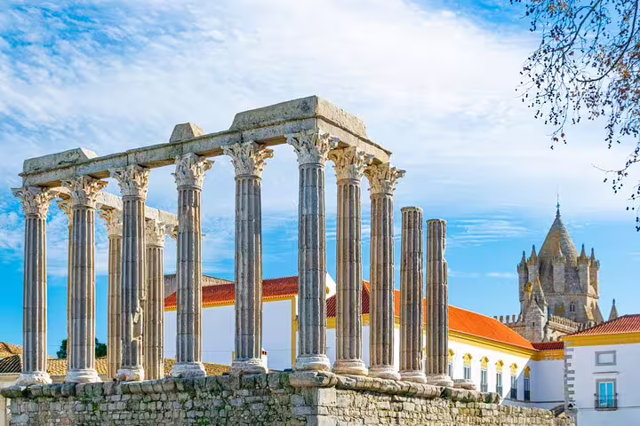 Ancient Roman Temple of Évora with medieval cathedral backdrop, showcasing the rich history on a private full-day tour.