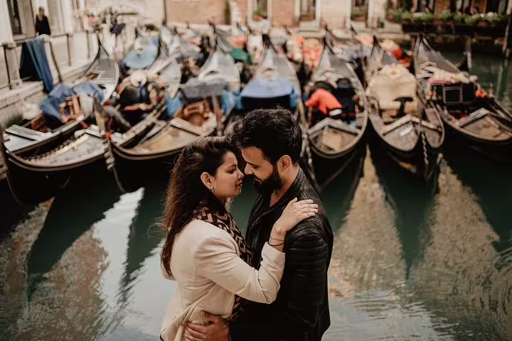Romantic couple photoshoot by gondolas on a Venice canal during a private travel photographer tour