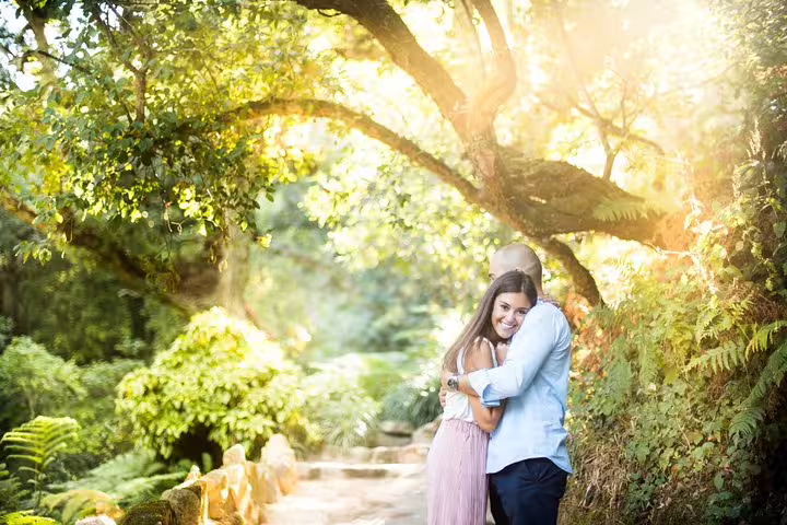 Romantic couple hug in lush Lisbon park at golden hour during private vacation photographer photo shoot