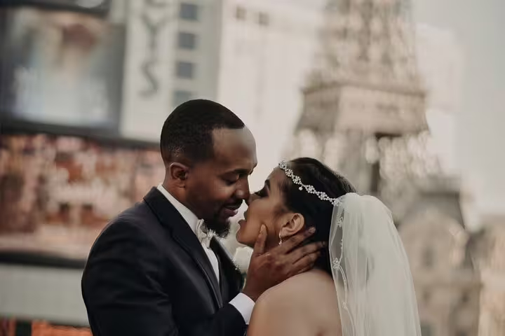 Romantic couple kiss with Paris Las Vegas Eiffel Tower backdrop during private vacation photographer tour