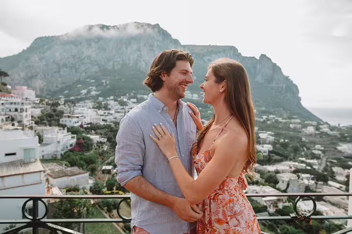 Romantic couple sharing a moment on a balcony overlooking the stunning landscape of Naples.