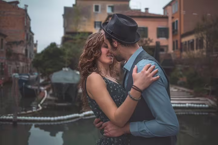 Romantic couple embrace by a Venice canal, candid city portrait session with local photographer in Italy