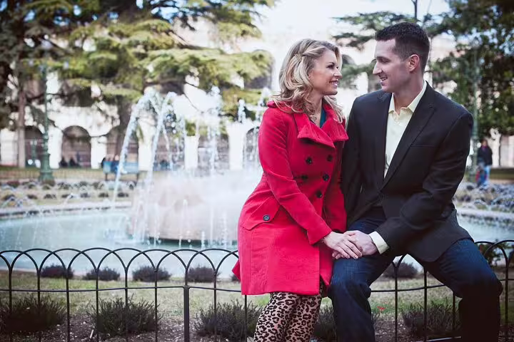 Couple enjoying a romantic moment by a fountain in Verona during a professional photoshoot tour.
