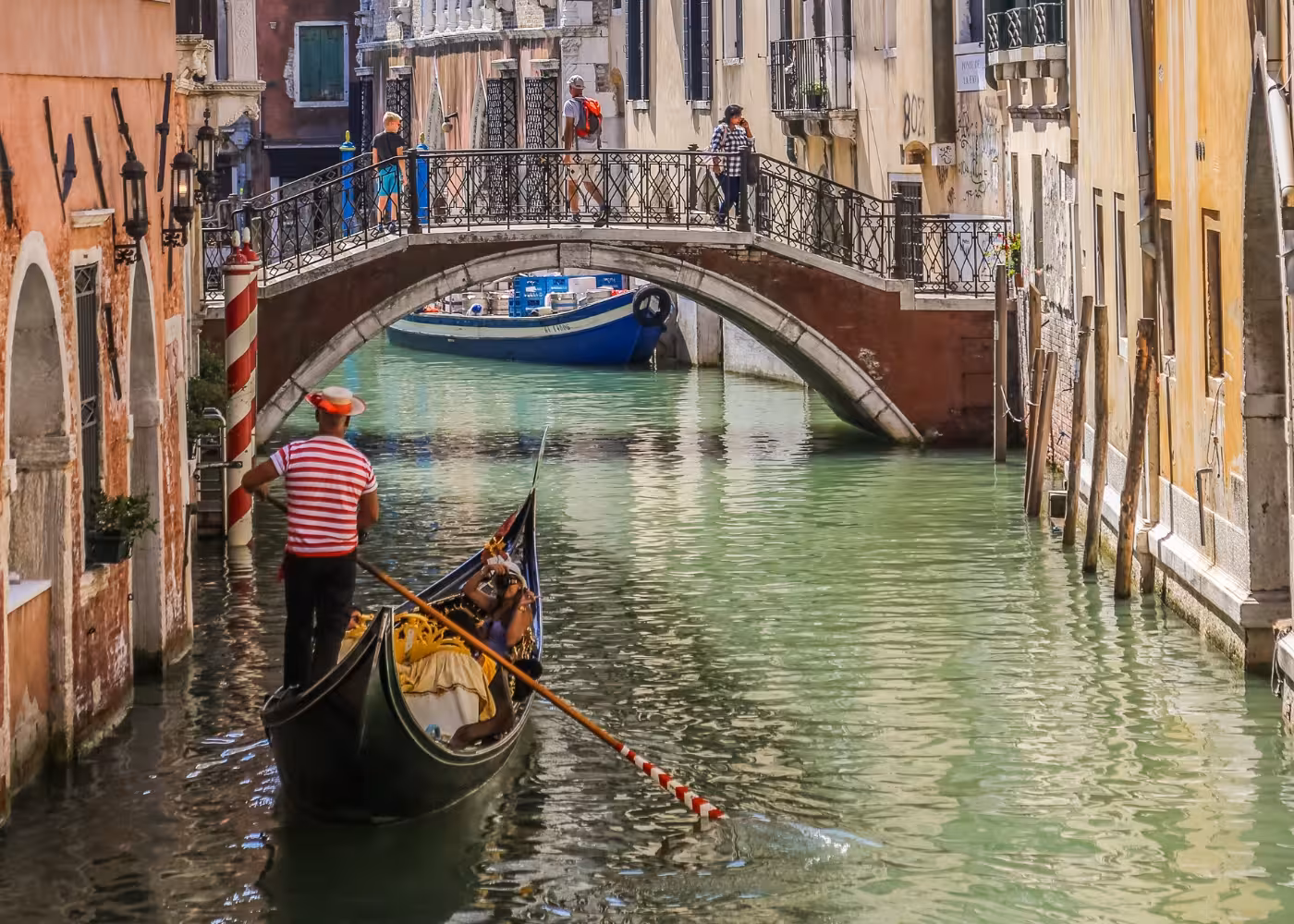 Charming gondola ride under a picturesque bridge on Venice's Grand Canal, perfect for a romantic sightseeing tour.