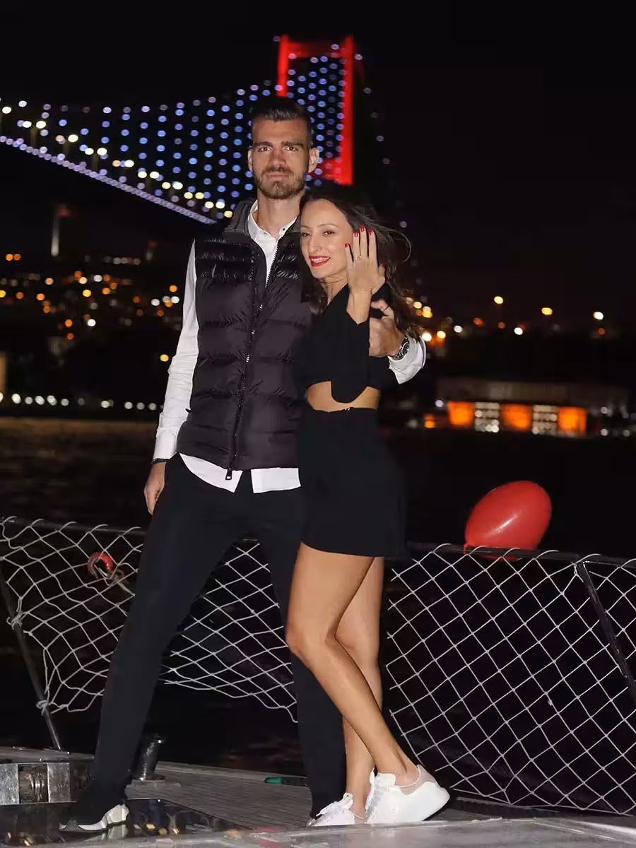 Happy couple on a private Bosphorus yacht with Istanbul bridge lights, romantic marriage proposal photo moment