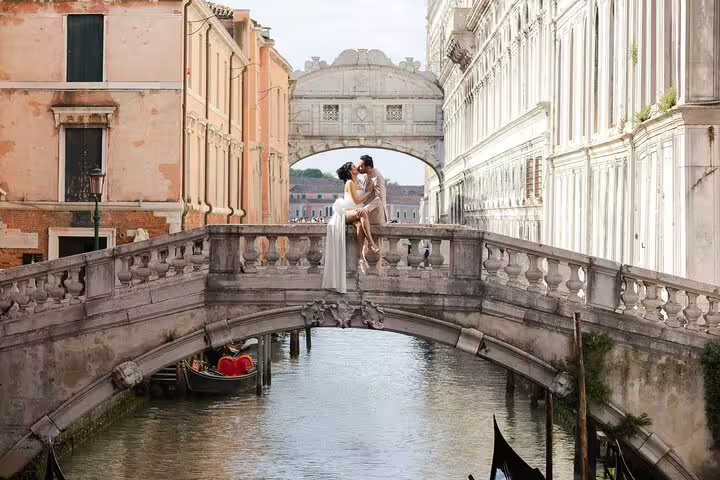 Romantic Venice city portrait session on Bridge of Sighs canal, couple kiss with gondola below