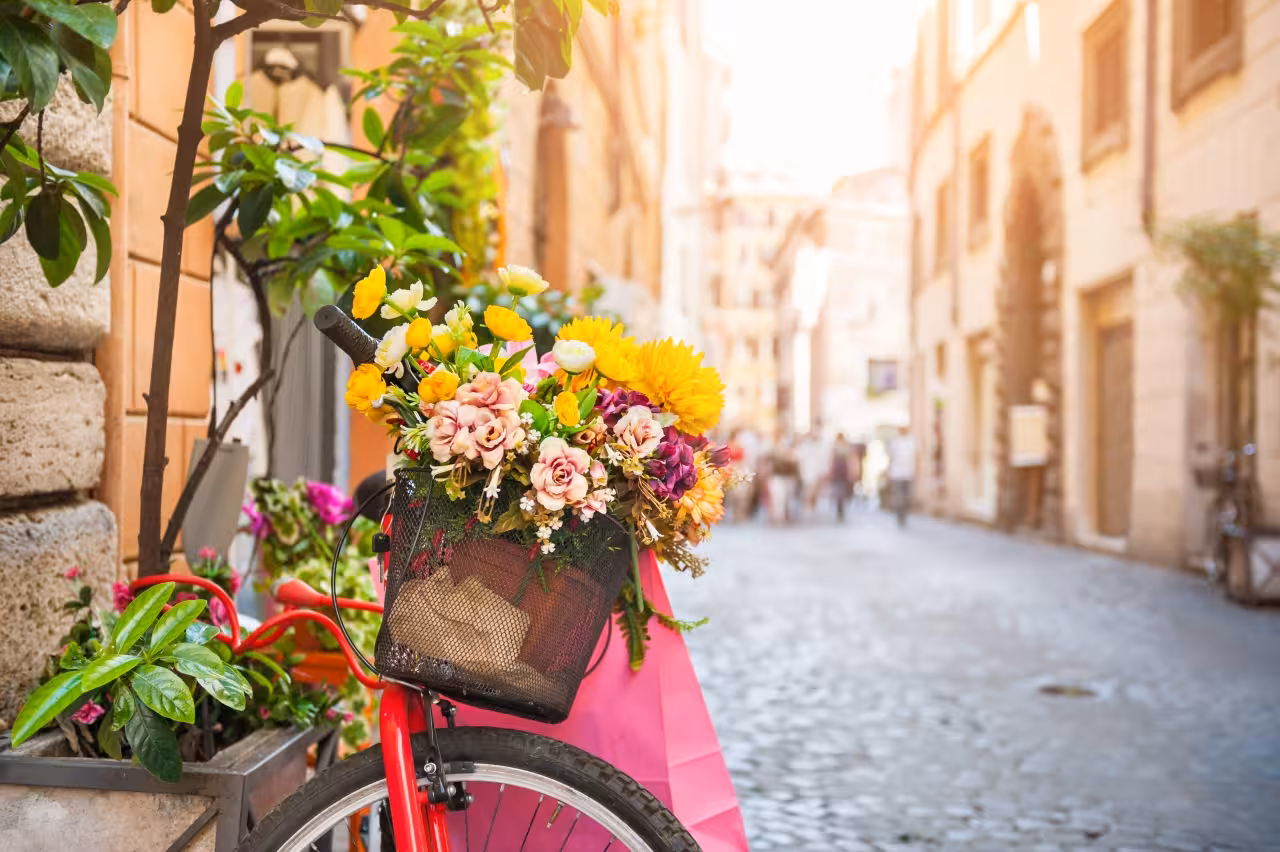 Flower-filled bicycle on a cobblestone Rome street, scenic moment on the Rome Ancient Amusement tour