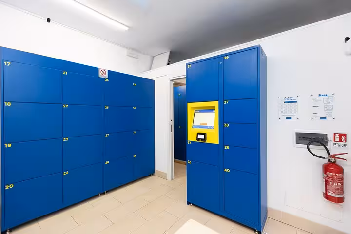 Spacious Rome Bag Storage area with blue lockers and digital kiosk for easy luggage management.