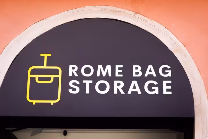 Close-up of Rome Bag Storage sign with a suitcase icon on a stylish arched entrance.