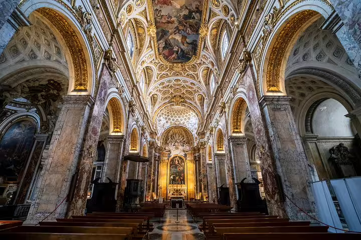 Lavish Baroque church interior in Rome with gilded arches and frescoes featured on a Caravaggio masterpieces private tour