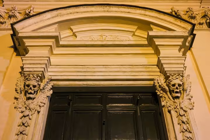 Intricately carved entrance with skull motifs on Rome's Bone Crypts tour, highlighting ancient artistry and mystery.