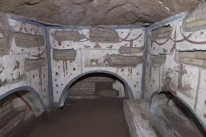 Stone burial niches and arched tombs inside the ancient Rome catacombs featured on Colosseum and underground tour tickets