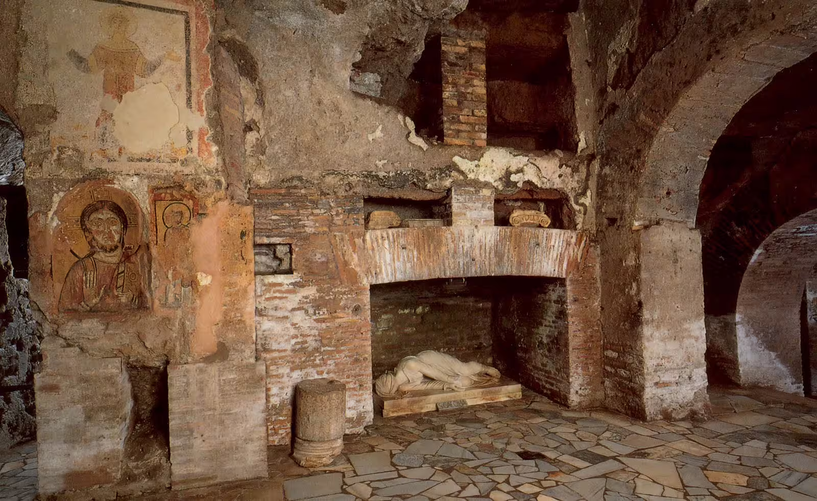 Ancient frescoes and marble sarcophagus in dimly lit Rome catacombs, revealing early Christian burial crypt beneath the city