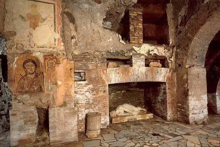 Ancient burial niches, frescoes and stone sarcophagus inside Rome’s catacombs visited on a private underground sightseeing tour