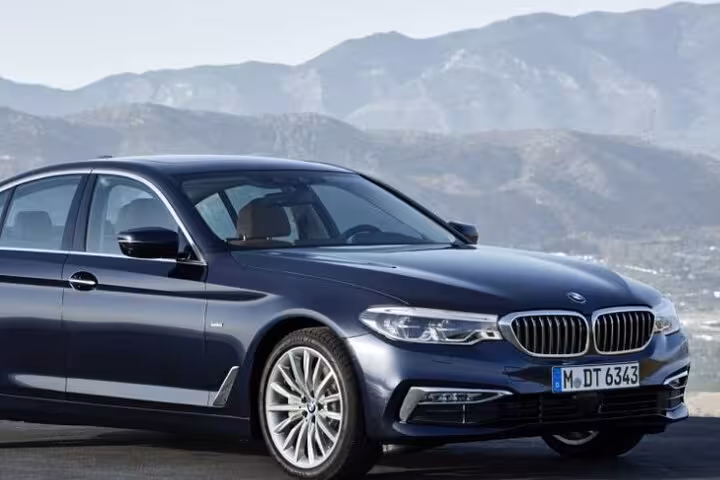 Elegant sedan offering premium transfer service from Rome to Civitavecchia Port with scenic backdrop.