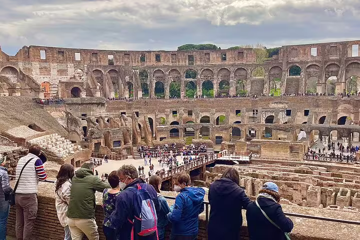 Visitors on a Rome Colosseum arena viewpoint during an exclusive Ancient Rome private guided tour with panoramic interior ruins