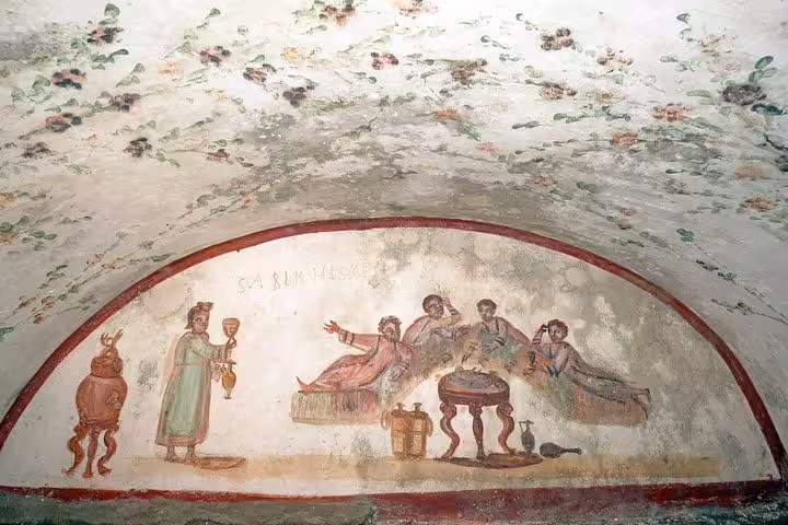 Colorful fresco of Romans dining and drinking on a vaulted catacomb ceiling, featured on Rome Colosseum underground tour