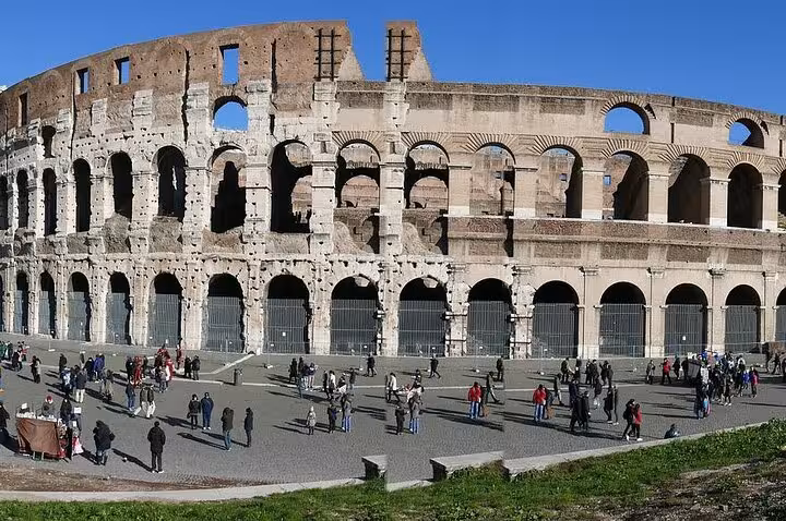 Tourists explore the exterior of Rome's iconic Colosseum, highlighting its historical and architectural significance.