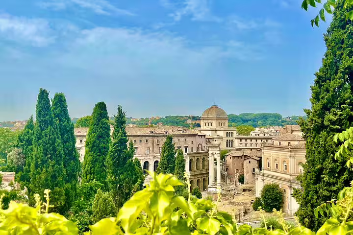 Panoramic view of ancient Roman ruins, domes and cypress trees on a Best of Rome Colosseum and city squares walking tour