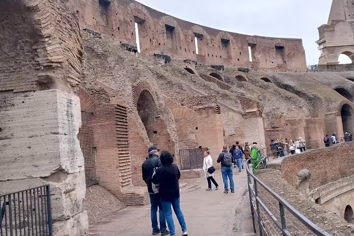 Visitors exploring the historic Colosseum arena in Rome on a guided underground and arena tour.