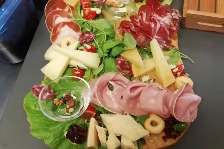 Italian charcuterie board with assorted meats, cheeses, and greens featured on Vatican's Craft Beer Private Tour with Local Foodie.