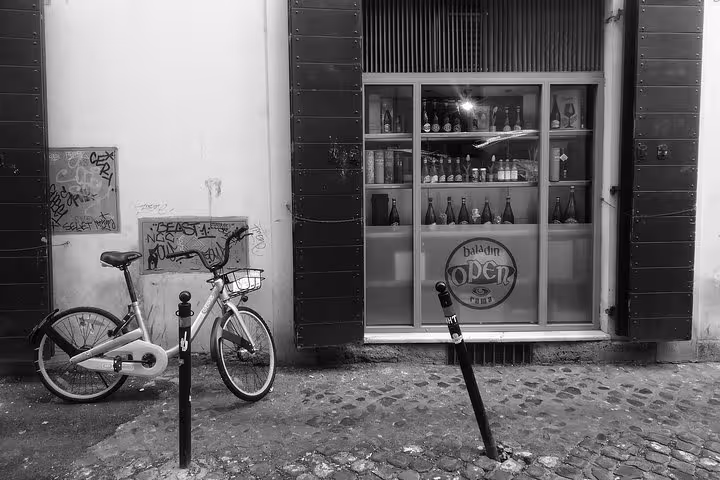 Charming Roman street with a bicycle and a craft beer shop, highlighting urban charm on the Local Beer Walk tour.