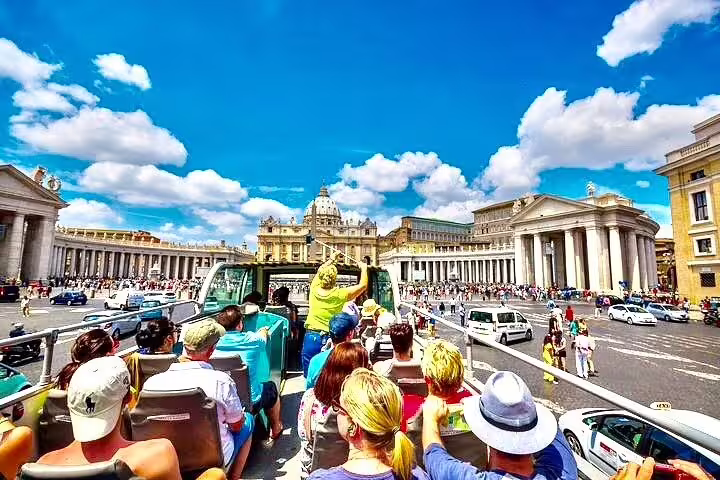 Tourists on a Rome open top double decker bus approaching St Peter’s Basilica and Vatican City on a guided city tour