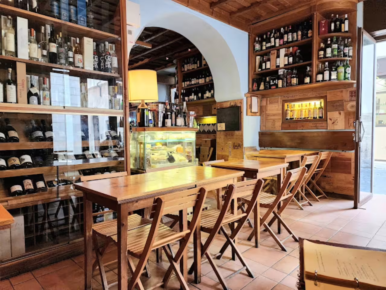 Cozy Rome enoteca interior with tasting tables and bottle-lined shelves for an exclusive city center wine tasting