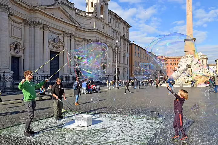 People enjoy creating giant soap bubbles in a sunny Roman piazza, perfect for family fun on the "Bella Roma" kids' tour.