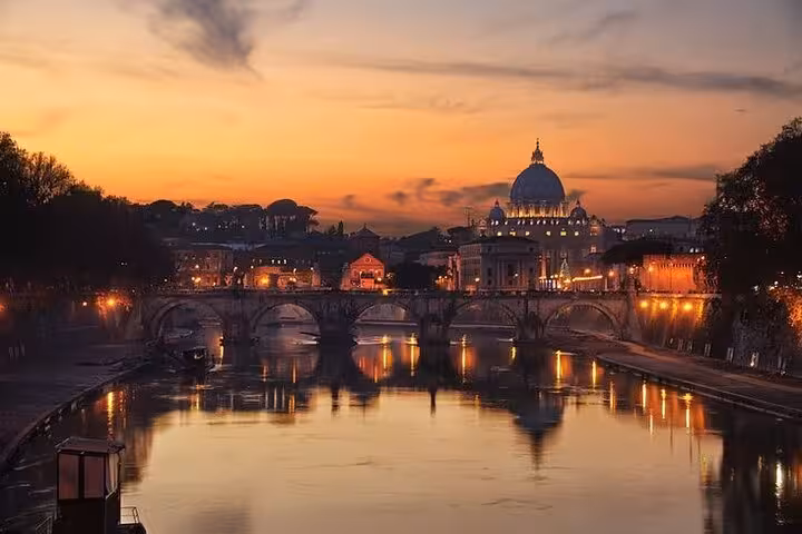 Scenic sunset view of Rome with St. Peter's Basilica and reflection on the Tiber River during a golf cart tour.