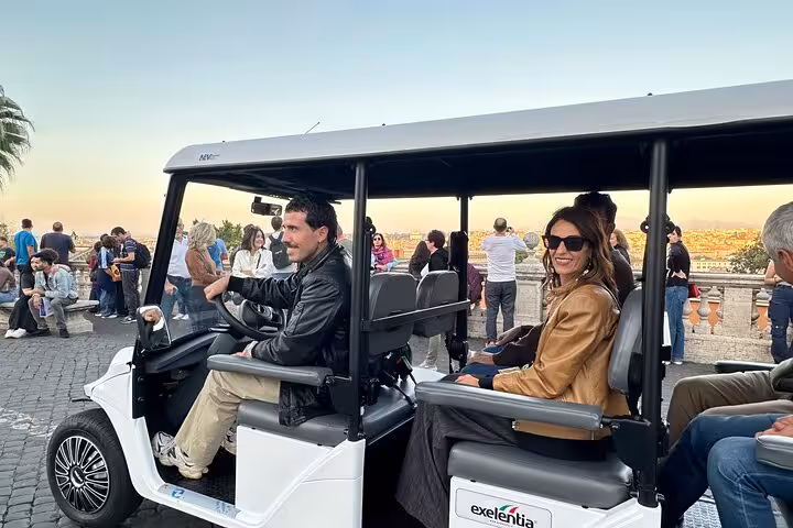 Visitors in a golf cart admire Rome's skyline during a guided tour with a local expert.