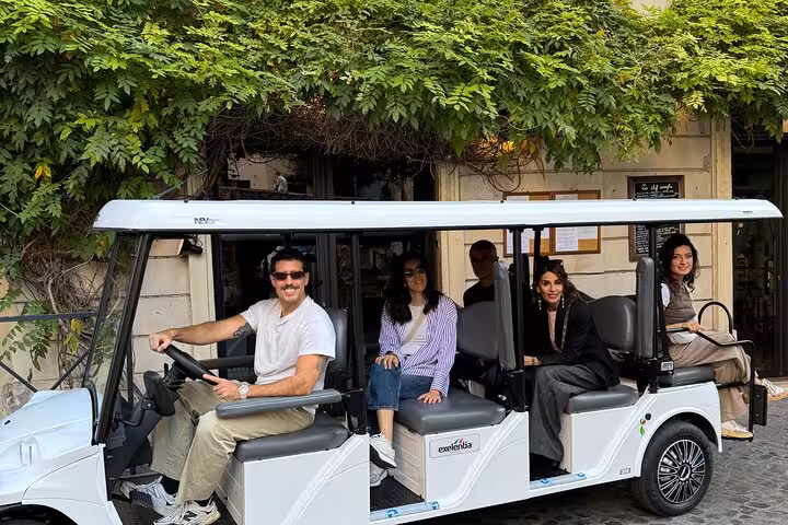 Group of tourists on a golf cart explore Rome’s picturesque streets with a local guide.