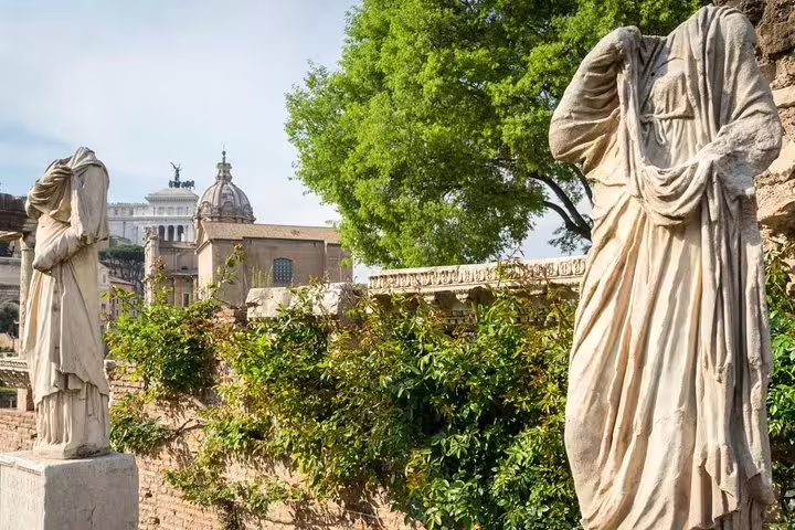Ancient Roman Forum marble statues and greenery seen on a Rome hop-on hop-off bus and Colosseum Vatican tour