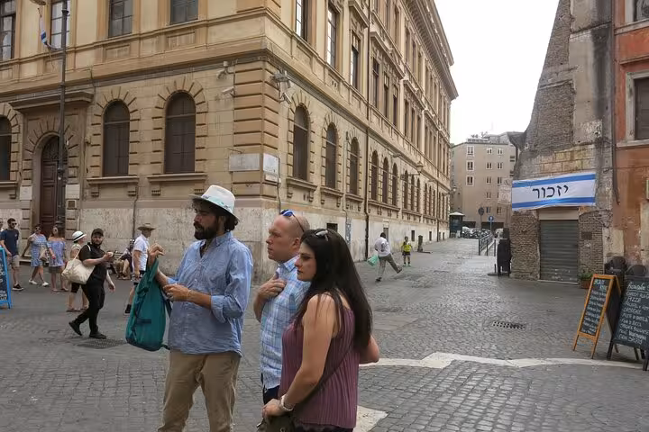 Tourists exploring the historic streets of Rome's Jewish Ghetto, surrounded by classic architecture and vibrant culture.