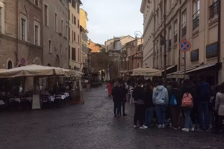 Busy street in Rome's Jewish Ghetto lined with outdoor cafes, capturing vibrant local atmosphere.