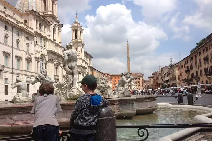 Children admire the Fountain of Neptune in Piazza Navona during a Rome kids friendly guided tour of historic highlights