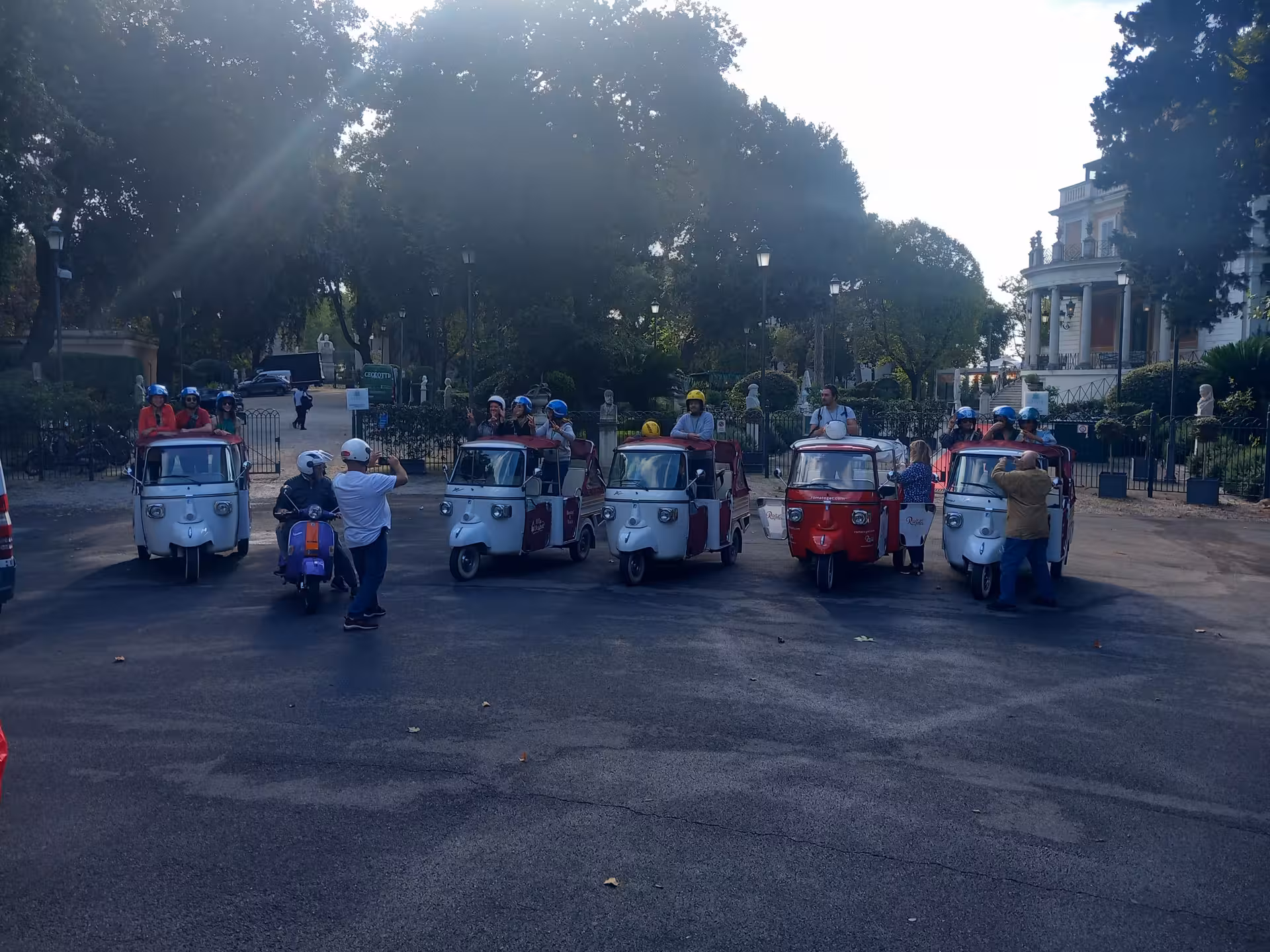 Line of colorful tuk tuks ready for a Rome city tour under sunny skies.