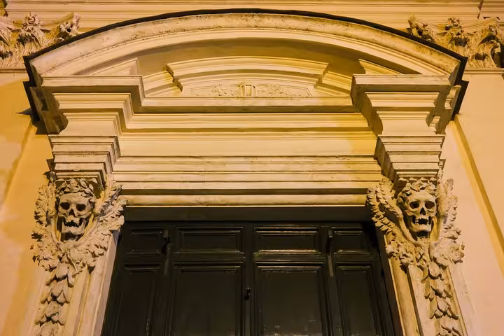 Ornate doorway with skull carvings in Rome, a highlight of the Dark Side Ghosts and Legends Tour.