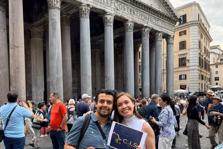 Couple posing in front of Rome's iconic Pantheon, highlighting its majestic columns and digital audio tour experience.