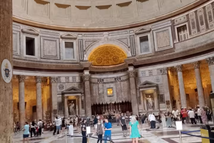 Discover the stunning interior of Rome's Pantheon, featuring ornate designs and bustling visitors with an enriching audio guide.