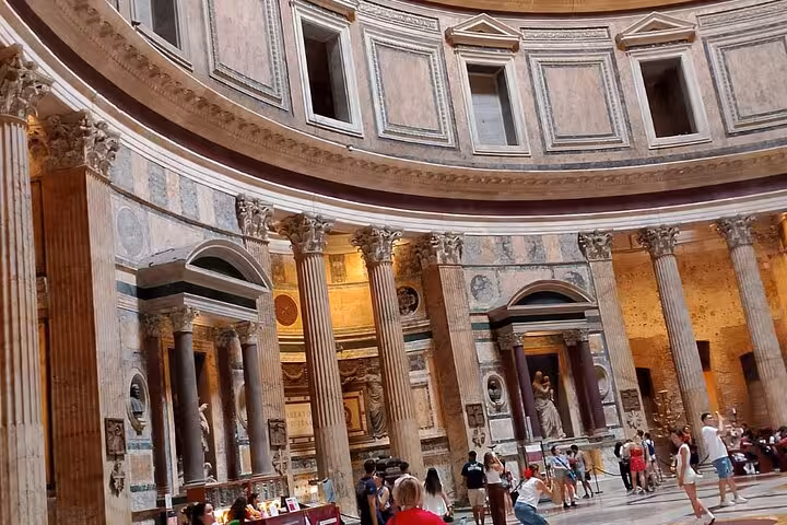 Explore the majestic interior of the Pantheon in Rome with its iconic columns and ancient statues on display.