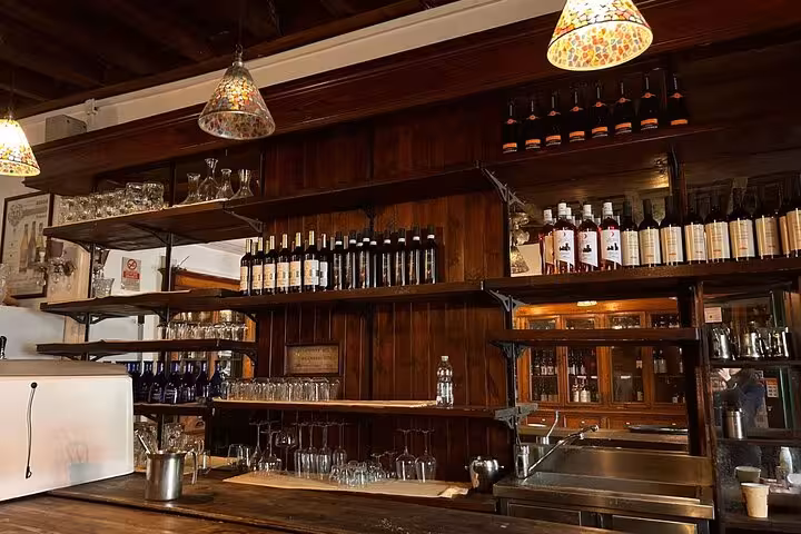 Cozy rustic bar setting with wine bottles and glasses, perfect for a culinary experience in Rome city center.