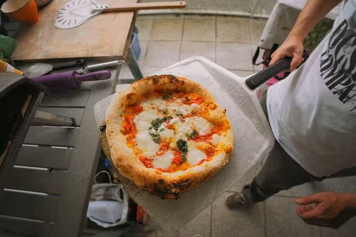 Close-up of freshly baked pizza during hands-on cooking class in Rome Highlights Tour.