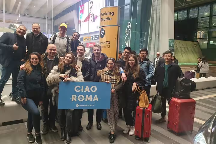 Private half-day Rome sightseeing tour group welcome at airport pickup with luggage and Ciao Roma sign
