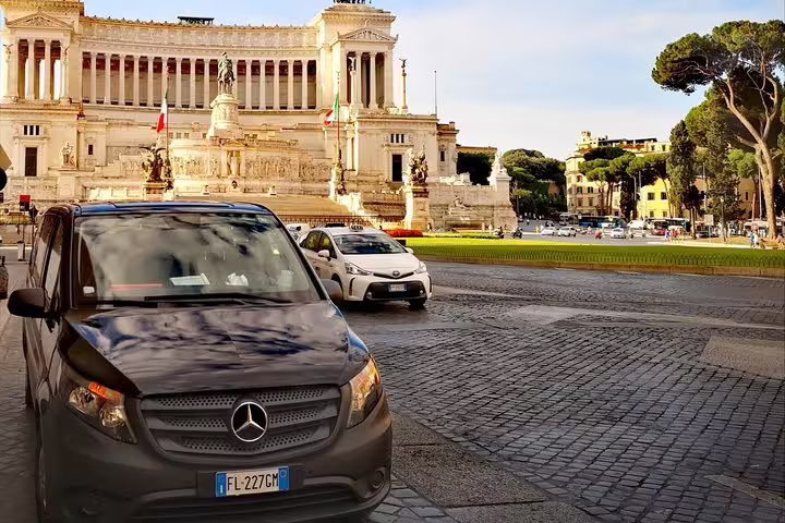 Private half-day Rome sightseeing tour van at Piazza Venezia with Vittoriano monument in background