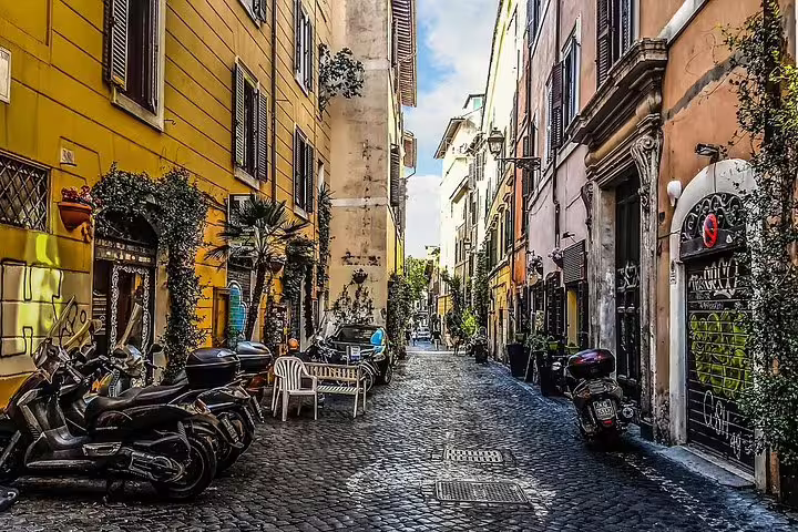 Rome private half-day sightseeing tour through a charming cobblestone alley in Trastevere with scooters