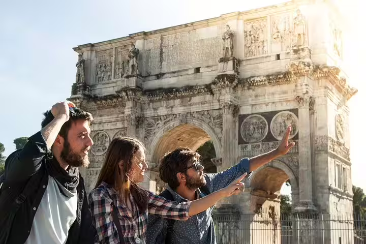 Tourists explore the Arch of Constantine during a private walking tour, discovering the hidden gems and iconic landmarks of Rome.